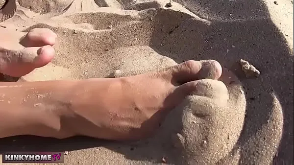 أنبوب Beach. Summer. The girl takes off her sneakers on the beach and plays with her feet كبير